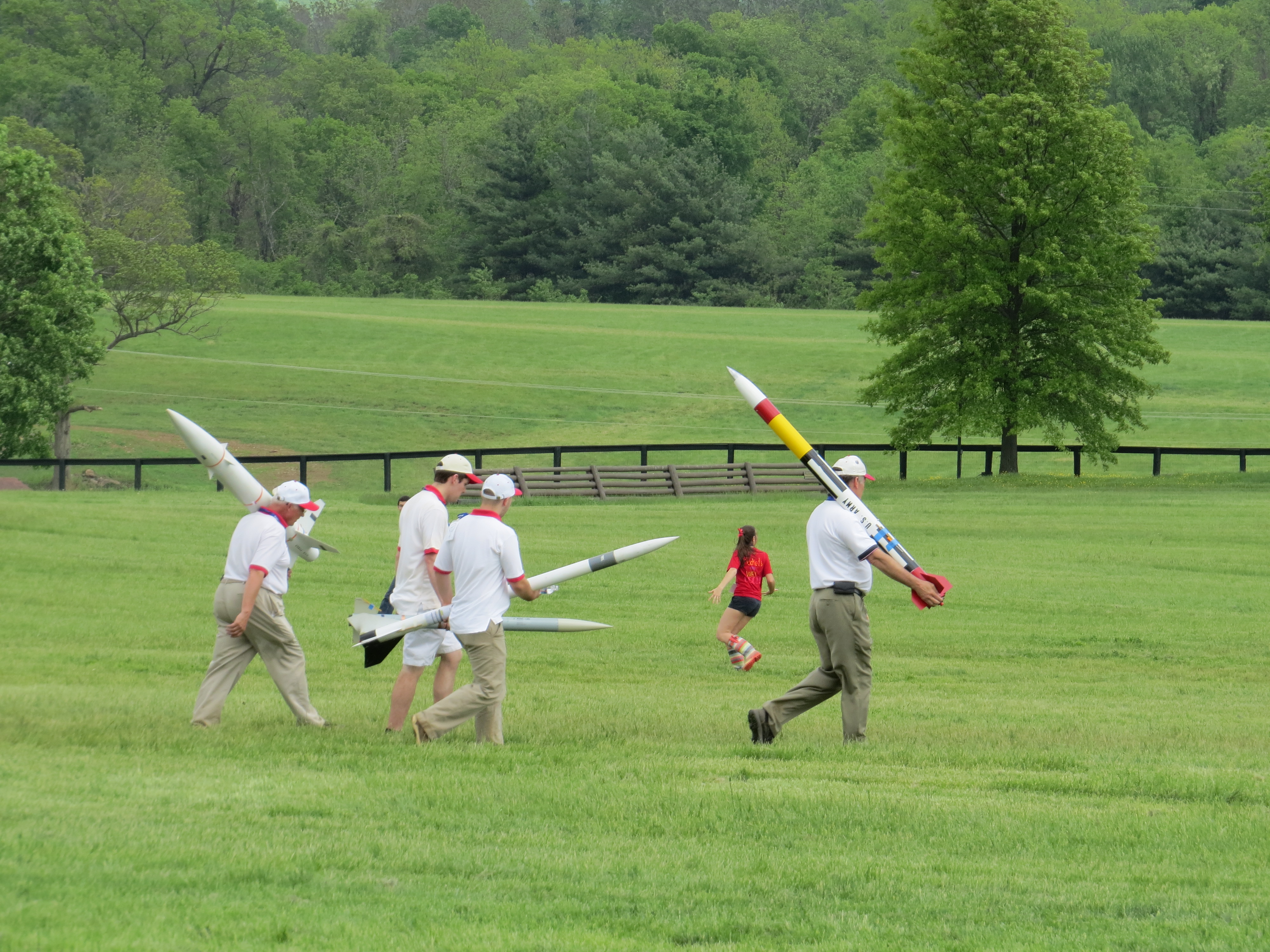 a group of people carrying rockets out to the field